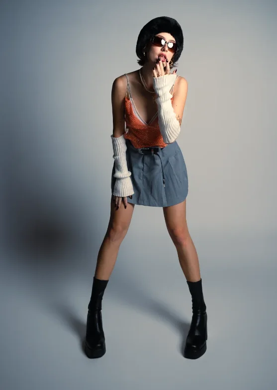 Artista de pie con pollera de jean y boina