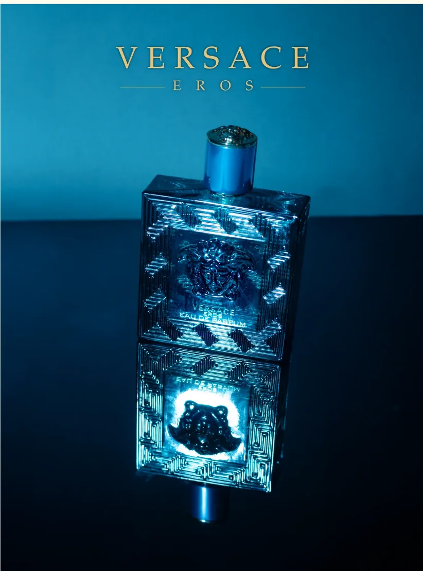 Frasco de Versace Eros sobre fondo turquesa con el logo de Versace
